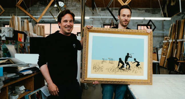 Timeless-Investments-Gründer Jan Karnath und OMR-Gründer Philipp Westermeyer präsentieren ein Bild von Banksy. Foto: OMR