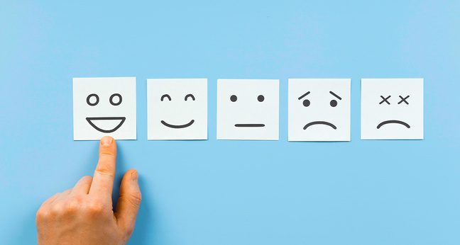 Fünf gezeichnete Gesichtsausdrücke von sehr glücklich bis unzufrieden auf Zetteln – Symbolbild für Mitarbeiterzufriedenheit und Feedbackkultur.