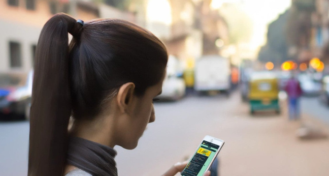 Eine junge Inderin erhält eine Werbe-Nachricht auf Whatsapp