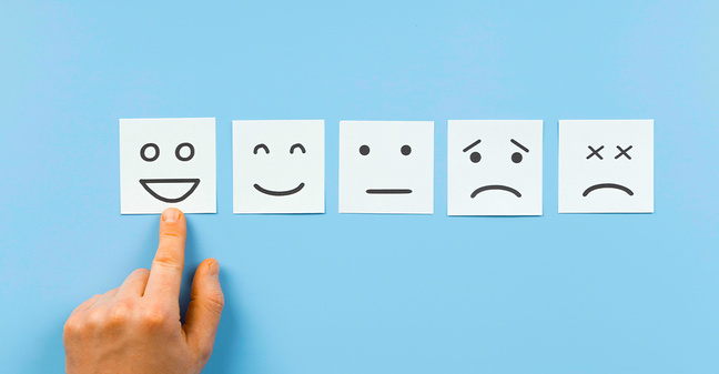 Fünf gezeichnete Gesichtsausdrücke von sehr glücklich bis unzufrieden auf Zetteln – Symbolbild für Mitarbeiterzufriedenheit und Feedbackkultur.