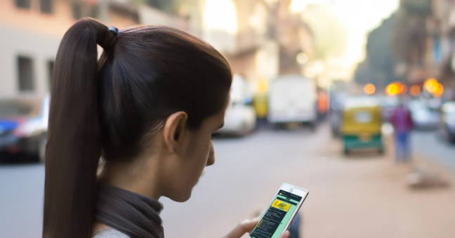 Eine junge Inderin erhält eine Werbe-Nachricht auf Whatsapp