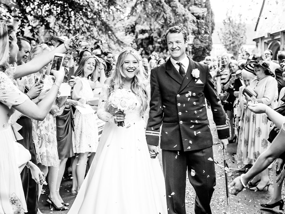 married couple exists, hand to hand, the church under a confetti shower